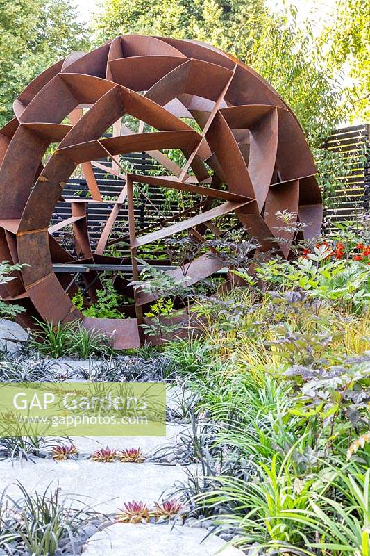 Corten steel sphere by William Roobrouck near foliage in 'Elements Mystique Garden', 
sponsored by Elements Garden Design 
