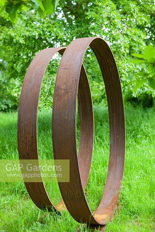 Moongates - circles of mild steel - set in grass with trees beyond
