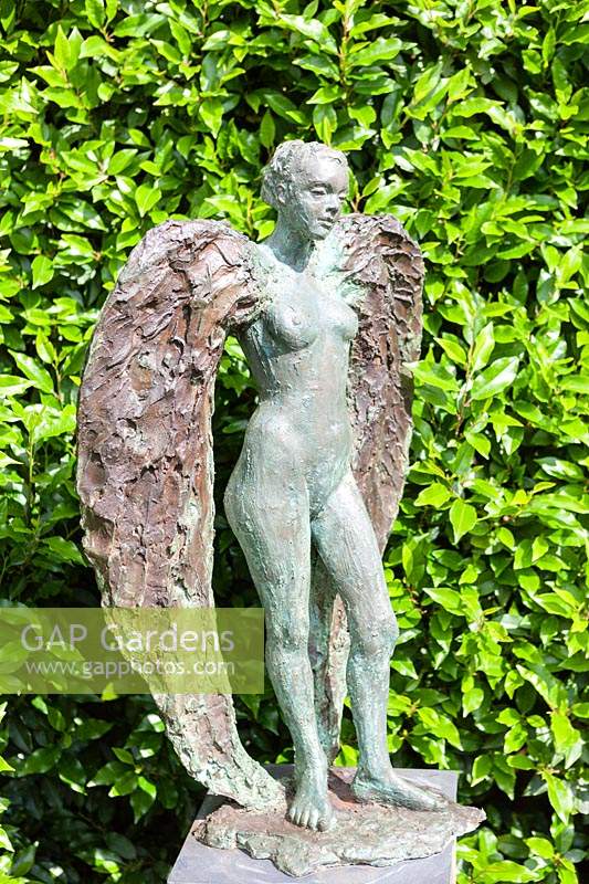 Sappho - sculpture in bronze and resin - against hedge
