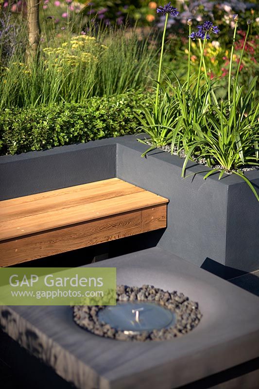 Detail of outdoor fireplace within seating area. Best of Both Worlds Garden, Sponsored by BALI, RHS Hampton Court Palace Flower Show, 2018.