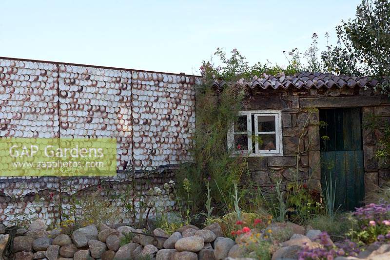 Shell wall, rocks, hut and coastal planting.  Rias de Galicia: A Garden at the End of the Earth. Designed by Rose McMonigall, sponsored by Turismo de Galicia. RHS Hampton Court Flower Show, 2018.
