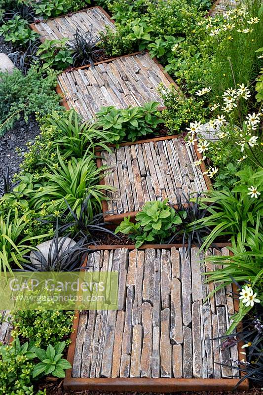 Rough stepping stones in the Through Your Eyes garden, designed by Lawerence Roberts and William Roobrouck, sponsored by Kebony, CED Stone Group, RandG Metal Products at RHS Hampton Court Garden Festival, 2019.
