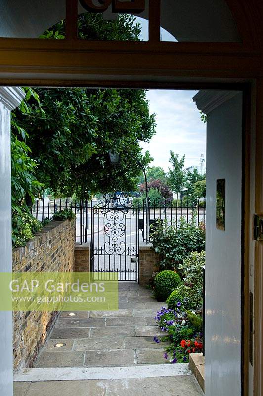 Formal metal gateway separates front garden from street.