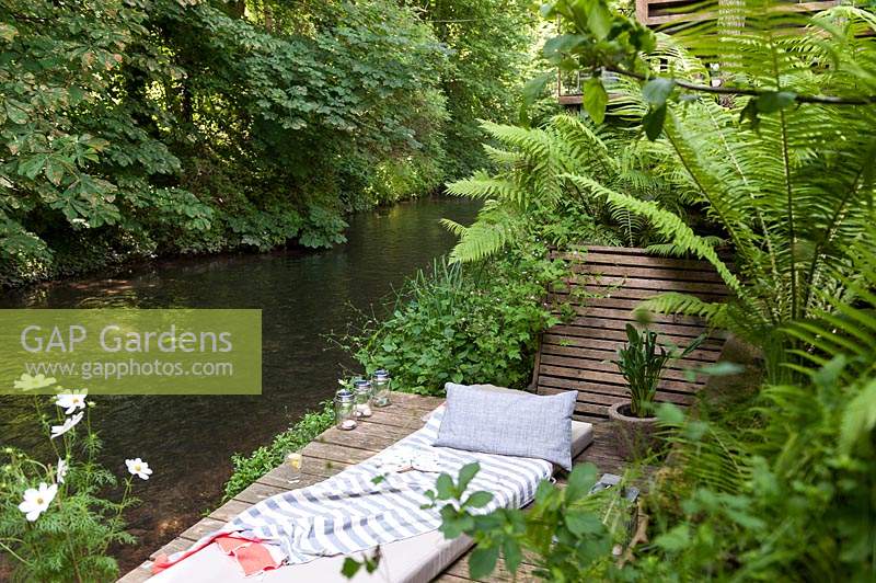 Secluded wooden decked terrace next to a creek 