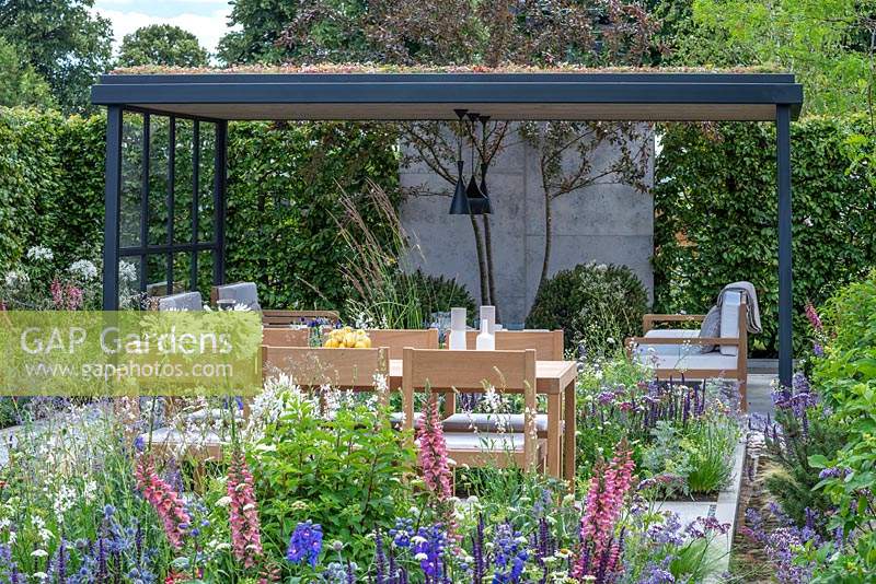 A contemporary garden for relaxing and entertaining, whilst keeping nature in mind with nectar rich planting, a green roof, trees, hedges and a water rill. The Viking Cruises Lagom Garden, designed by Will Williams, RHS Hampton Court Palace Garden Festival, 2019. 