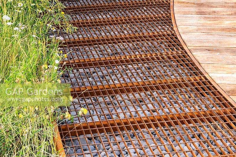 A metal grid filled with pebbles to aid water retention. RHS Hampton Court Palace Garden Festival 2019. Sponsor: Thames Water.