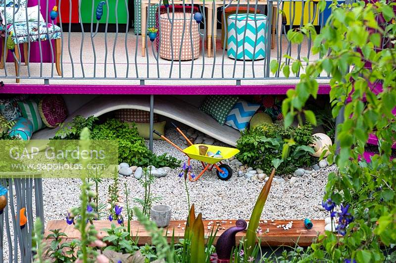 The childrens garden with lots of colurful planting and play equipment in the Montessori Centenary Children's Garden at RHS Chelsea Flower Show 2019