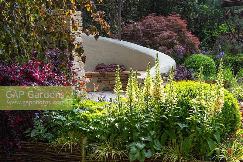 The Kingston Maurward Garden. A romantic curving seating area in Purbeck stone, enclosed in purple beeches, acers and herbaceous planting. Sponsors: Miles Brown, Kingston Maurward College, Goulds Garden Centre, Wilks Landscaping, Holme for Gardens, The Green Gardener.