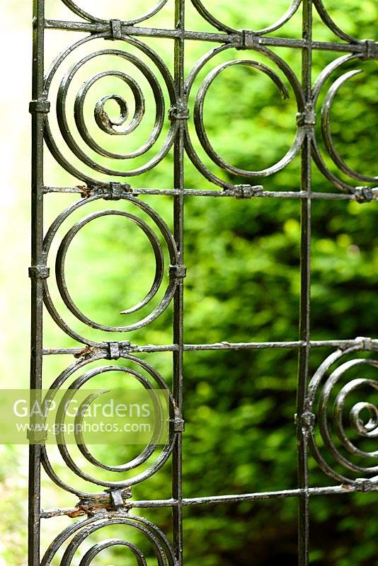 Elegant wrought iron gate of squares and circles at York Gate garden, Adel in July.