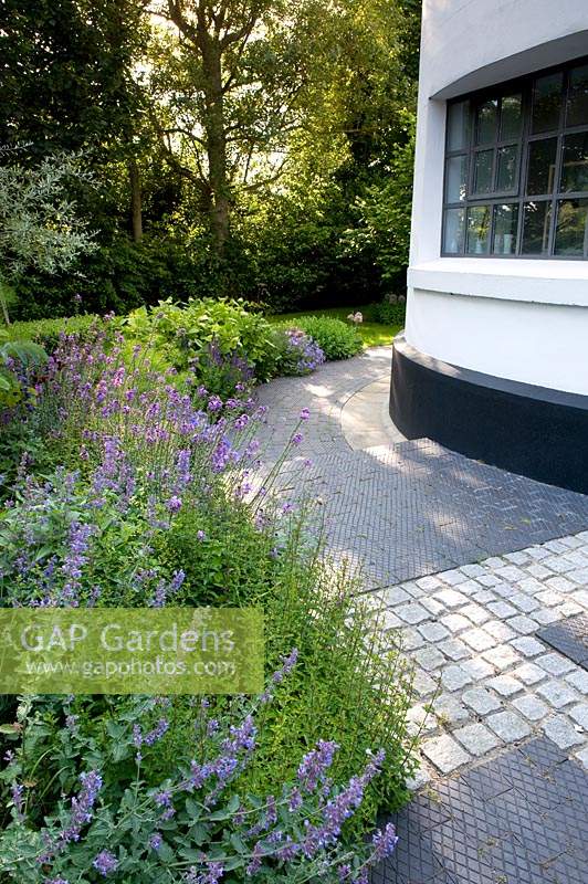 Curved perennial flowerbed and paving by converted Lighthouse. 