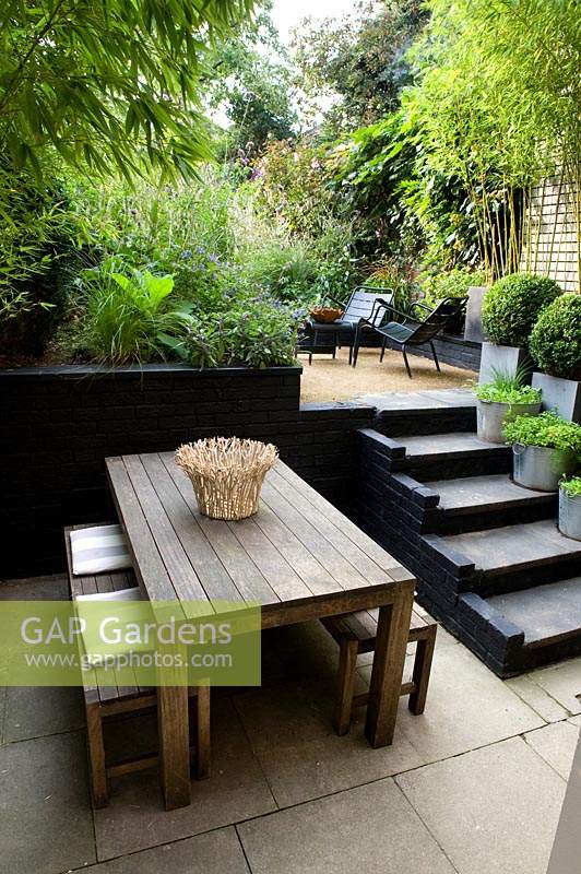 View from dining area with steps up to a multi-level urban garden
