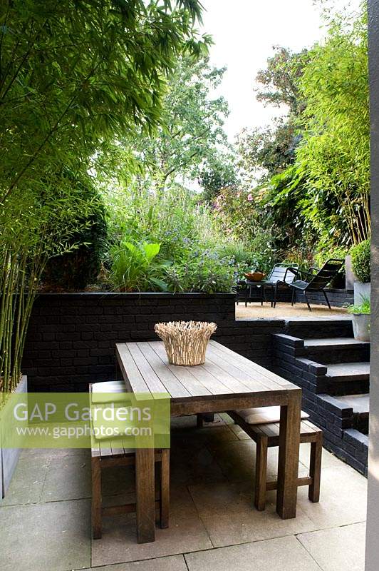 View from dining area with steps up to a multi-level urban garden
