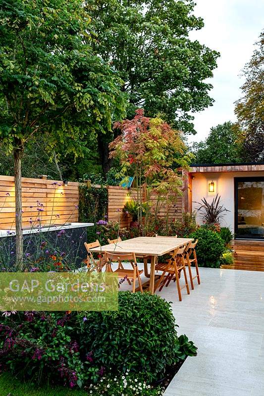 Contemporary garden in Wandsworth showing garden lighting. With stone patio, seating, tables and garden room 