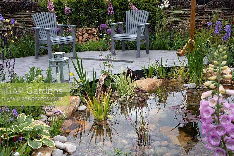 'RHS Garden for Wildlife Wild Woven' - RHS Chatsworth Flower Show 2019 - pond with curved deck and seating area, amongst naturalistic planting.