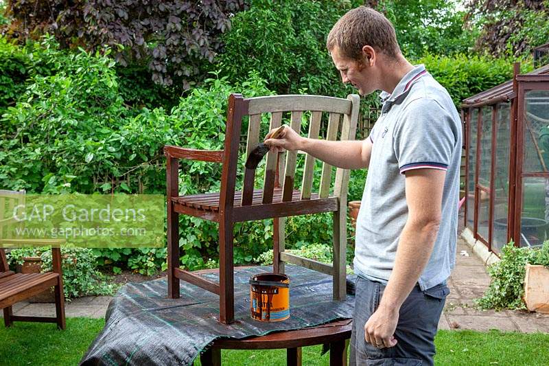 Painting garden furniture with preservative. 