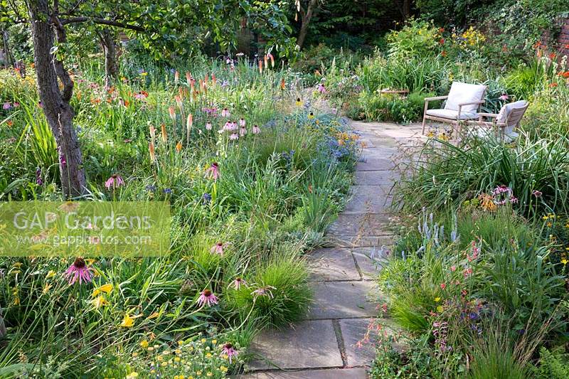 View of mixed border and pathway leading to a garden room in Dr. James Hitchmough's garden, Sheffield. August.
