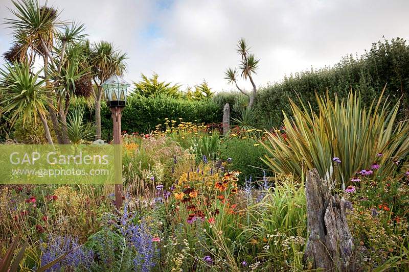 The Beth Chatto Garden with glass domed bird table, grasses, Echinacea, Rudbeckia, Perovskia, Phormium, Cordyline and Crocosmia