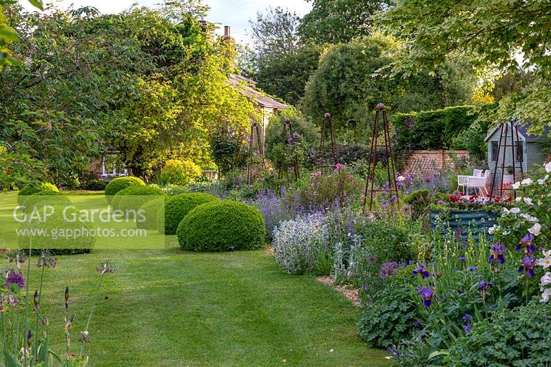 A garden that combines open vistas and overflowing beds to make for a relaxed natural feel, while box hedges and clipped balls give it structure.