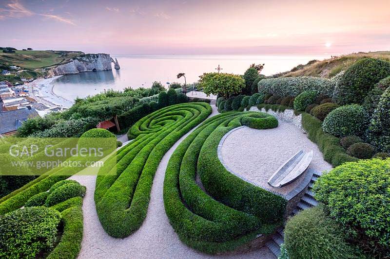 View over sculpted Phillyrea angustifolia spirals and views to the white cliffs and sea beyond. 