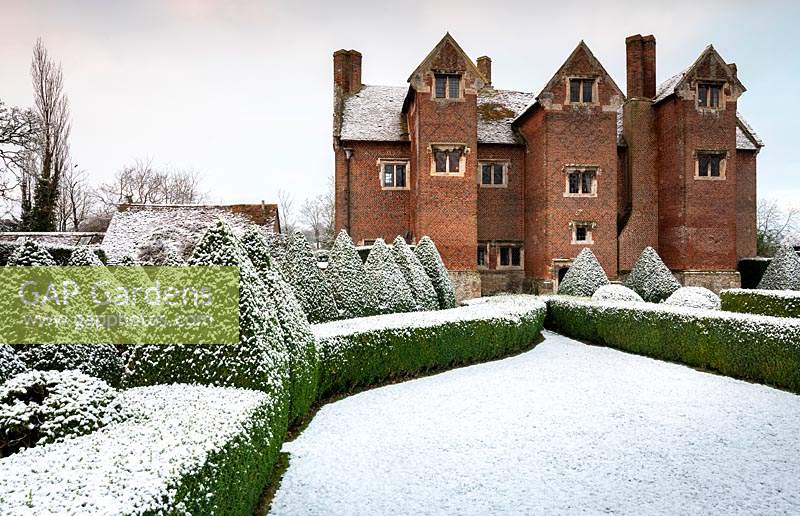 Box hedges and pyramids covered in snow at Beckley Park, Oxfordshire, UK.
