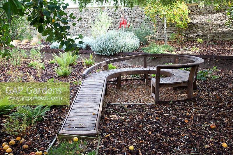 Sculptural wooden bench in autumn Garden. Radcot House, Oxfordshire, UK