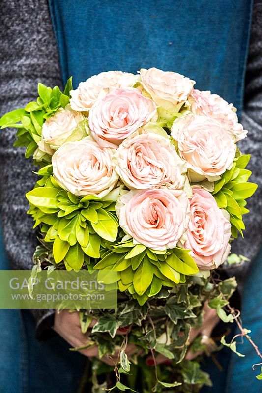 Bouquet of fragrant choysia ternata leaves, roses and ivy branches. 