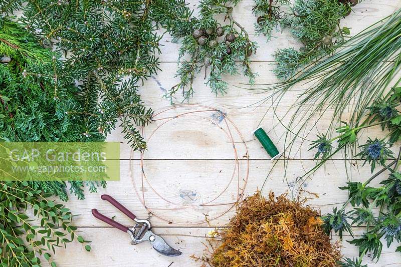 Tools and materials required to make green-themed winter wreath. 
