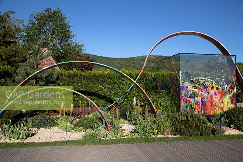 Glass cube structure and painted hoops in the What If In Support of Rees Foundation Garden 