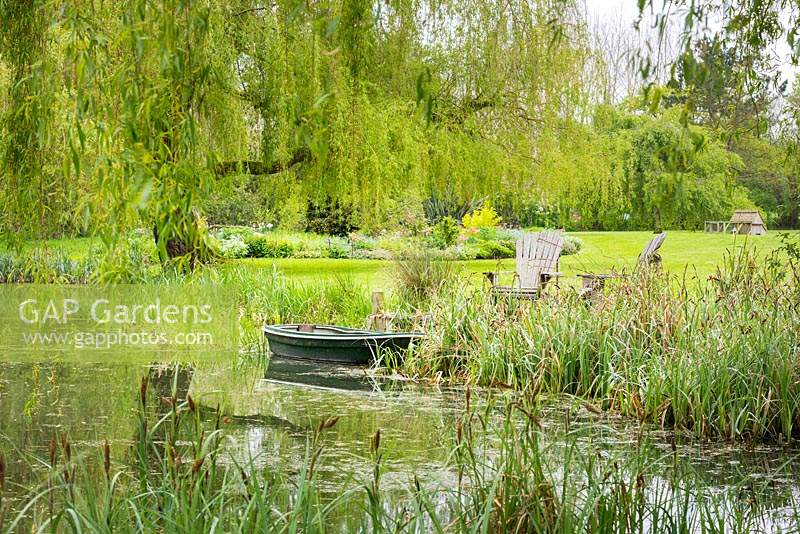 Seating area by the lake and weeping willow tree. 