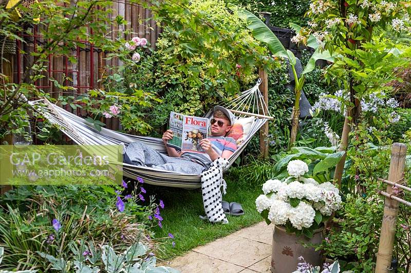Garden owner Ross relaxing in hammock while reading