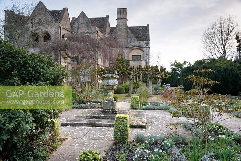The Leisure Garden with a stone urn and variegated clipped box at its centre, Rodmarton Manor, Glos, UK.
