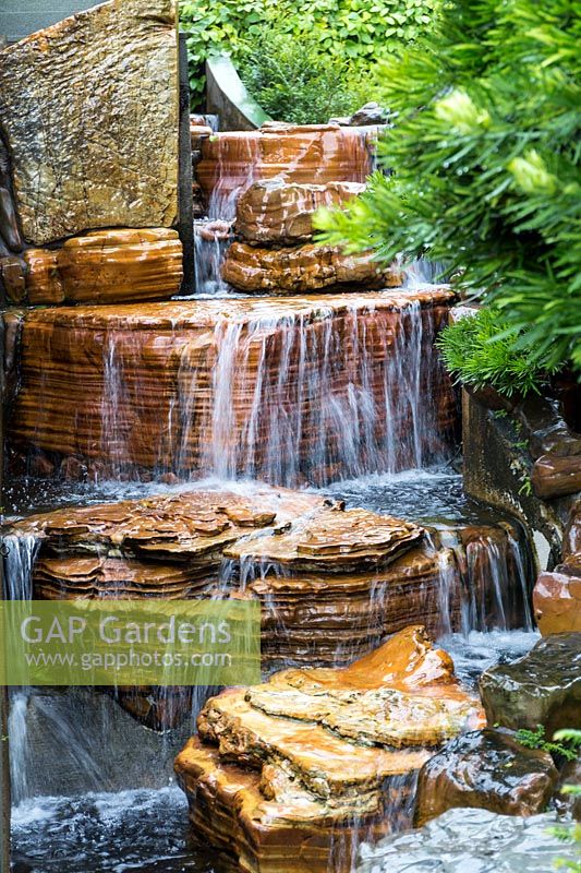 Water cascade, waterfall swelled by recent rain, next to the steps up to Chi Lin Nunnery from Nan Lian Garden. The colourful rock comes from the Hongshui River, part of the Pearl Delta. Hong Kong