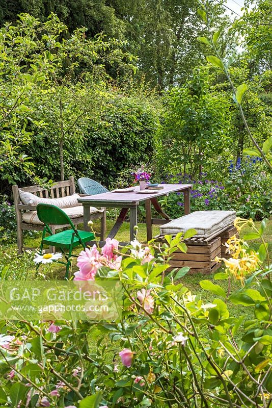 Table and chairs in garden with recycled and vintage seating