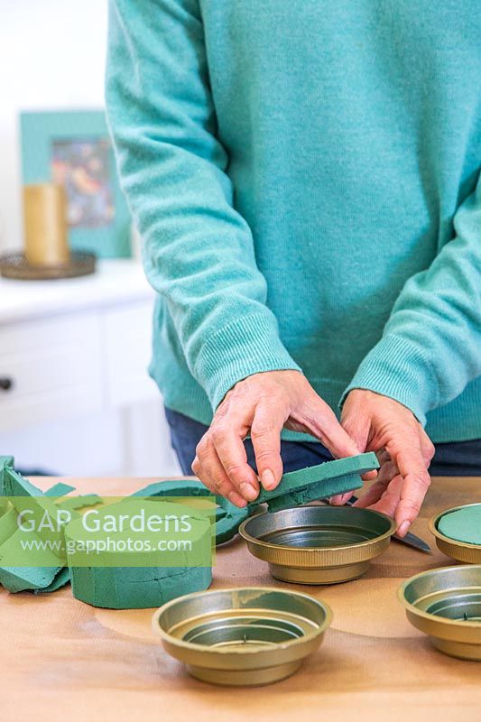 Woman adding oasis to holders to keep the foliage fresh