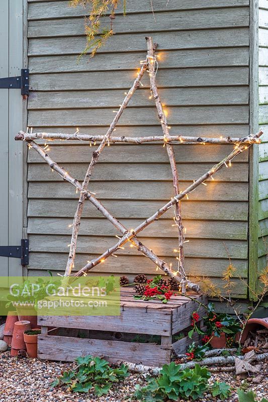Illuminated natural star leaning against wooden shed