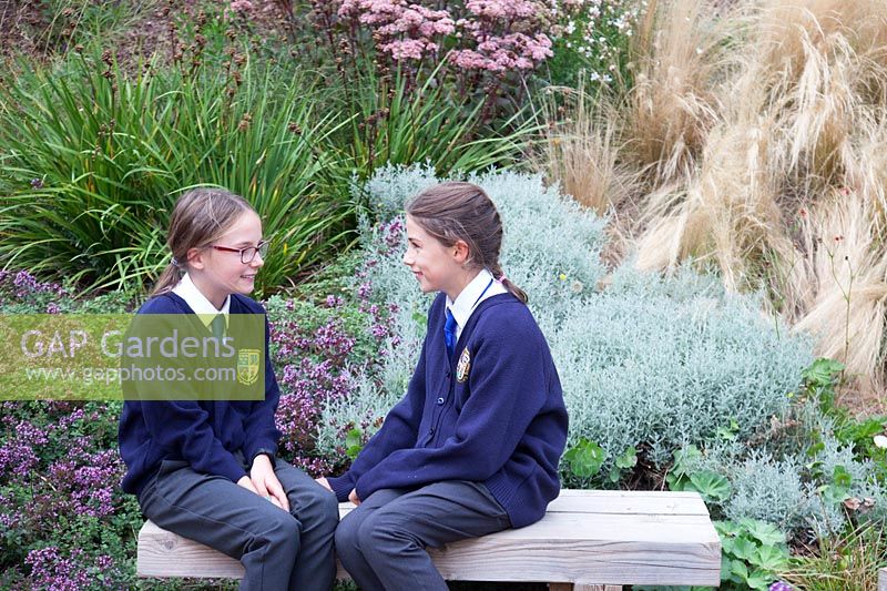 School pupils enjoying the garden at Sedlescombe Primary School, Sussex, UK. 