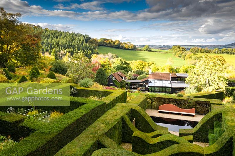 View over hedge gardens to house and surrounding countryside. Hedges of clipped Taxus baccata - Yew 