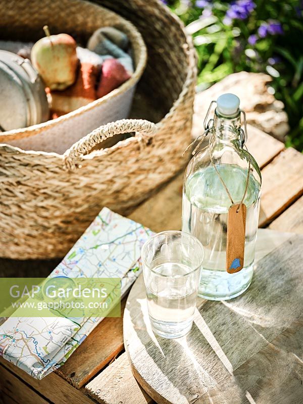 Wooden bottle tag with painted bluebell, glass bottles and glasses. 