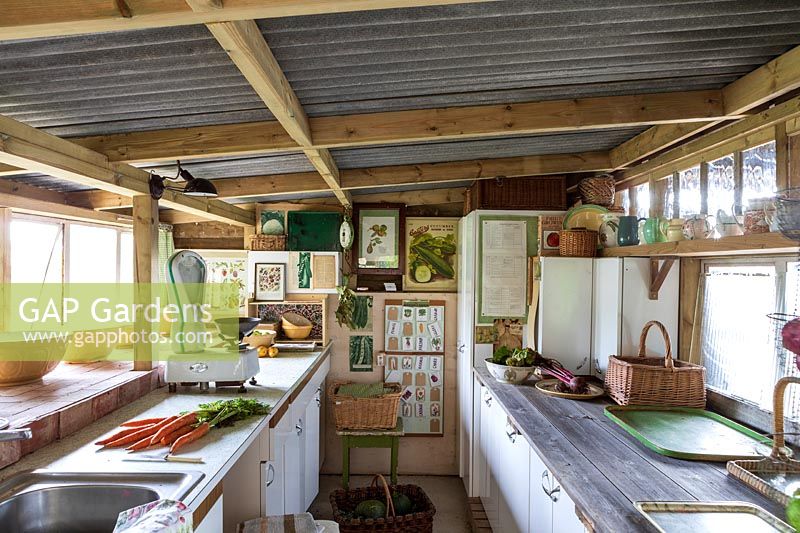 Old fashioned vintage kitchen area for vegetable preparation in garden room, filled with gardening paraphanalia