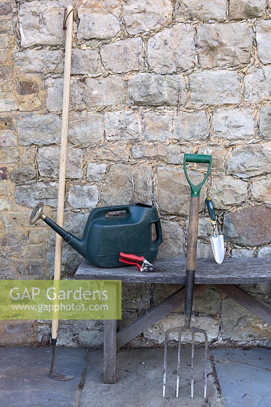 Essential garden tools of a Hoe, fork, trowel, watering can and secateurs