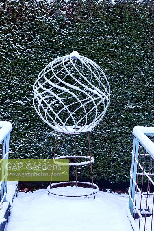 Spiral globe of mild steel with snow. Veddw House Garden