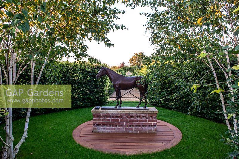 Statue of Kauto Star surrounded by a beech hedge and Betula utilis 'Jacquemontii'