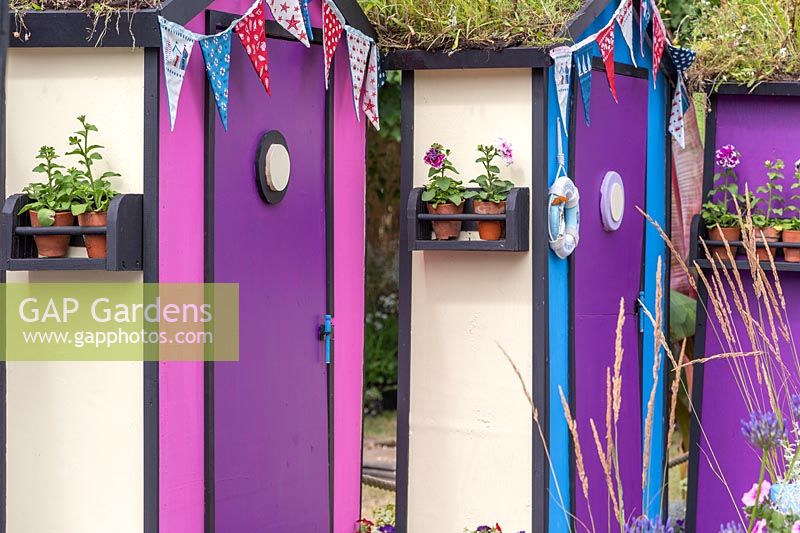 Colourful beach huts with wildflower green roofs and bunting. Fun on Sea, RHS Hampton Court Palace Flower Show, 2017. Design: Tony Wagstaff.
