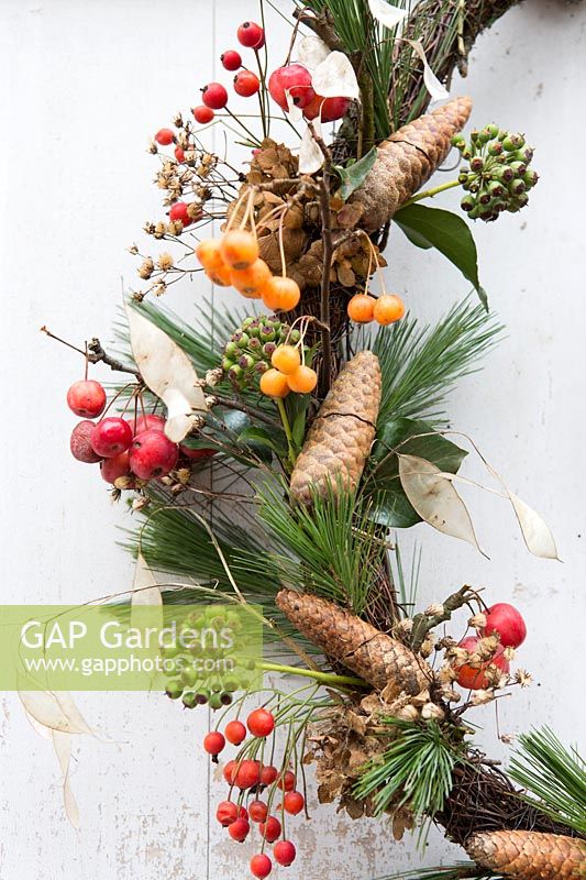 Detail of wreath with rosehips, crab apples, ivy seedheads, pine cones, pine foliage and papery seedheads. Styling by Marieke Nolsen. 