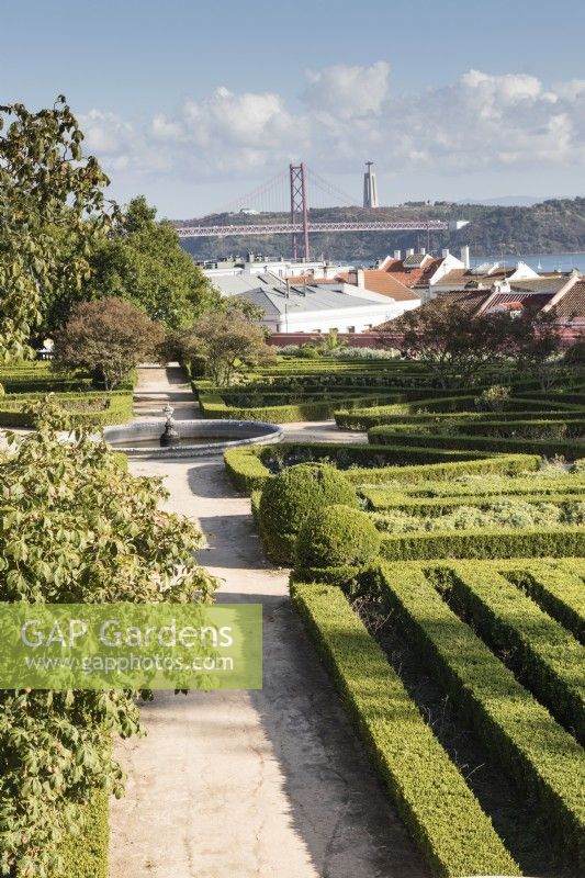 View over parterre to the River Tajus, the 25th April suspension bridge and the monument of Christ the King. Ajuda, Lisbon, Portugal, September.