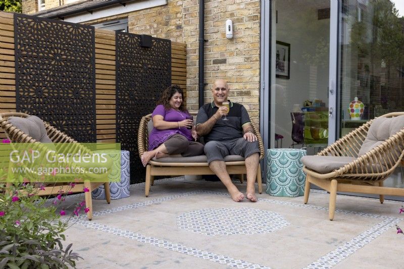 Couple seated on patio by house