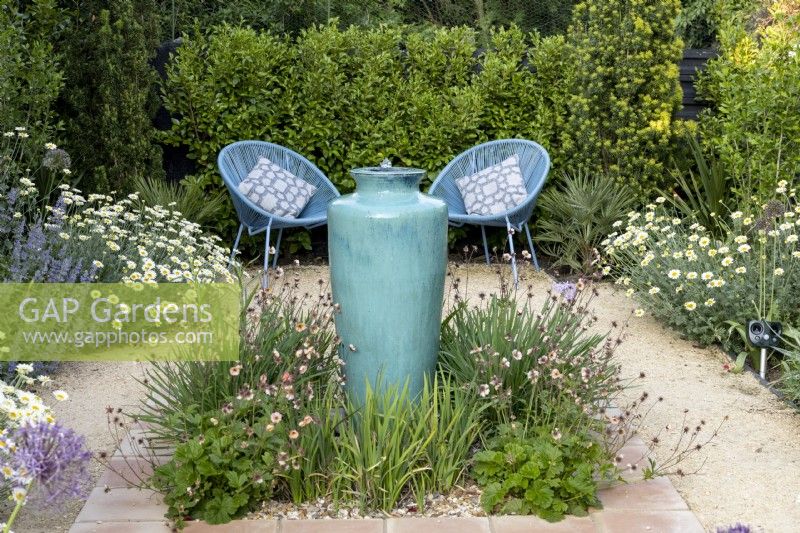 Tall ceramic container water feature in suburban garden