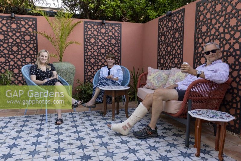 Couple relaxing with their daughter in their Moroccan style garden in suburban garden