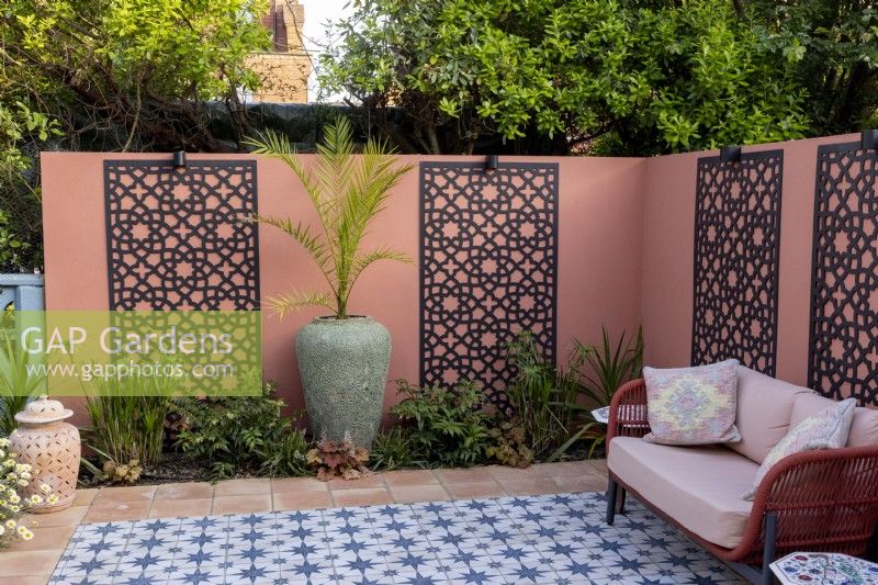 Moroccan style patio in suburban garden with decorative screens on wall