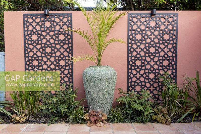 Phoenix Palm against brightly coloured wall with decorative screens